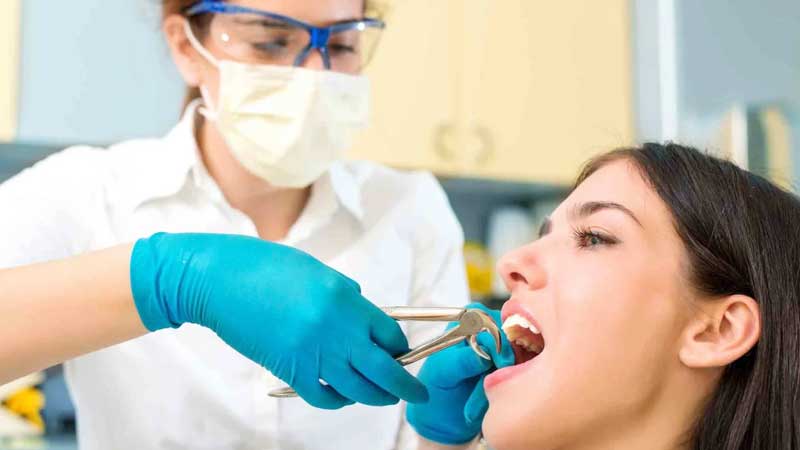 Dentist performing Tooth Removal on patient who has tooth pain