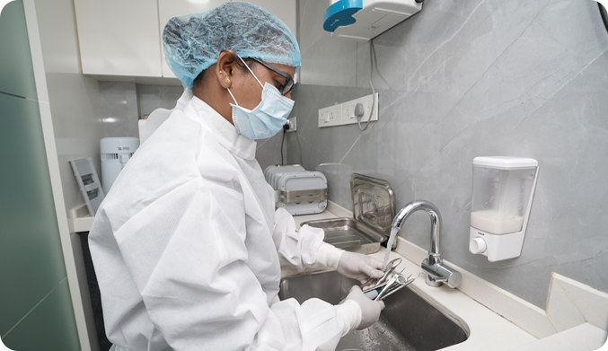 The dental treatment assistant washing dental tools like Mouth Mirror,Explorers, Probes, Scalers with distilled purified water to maintain 100% hygiene 